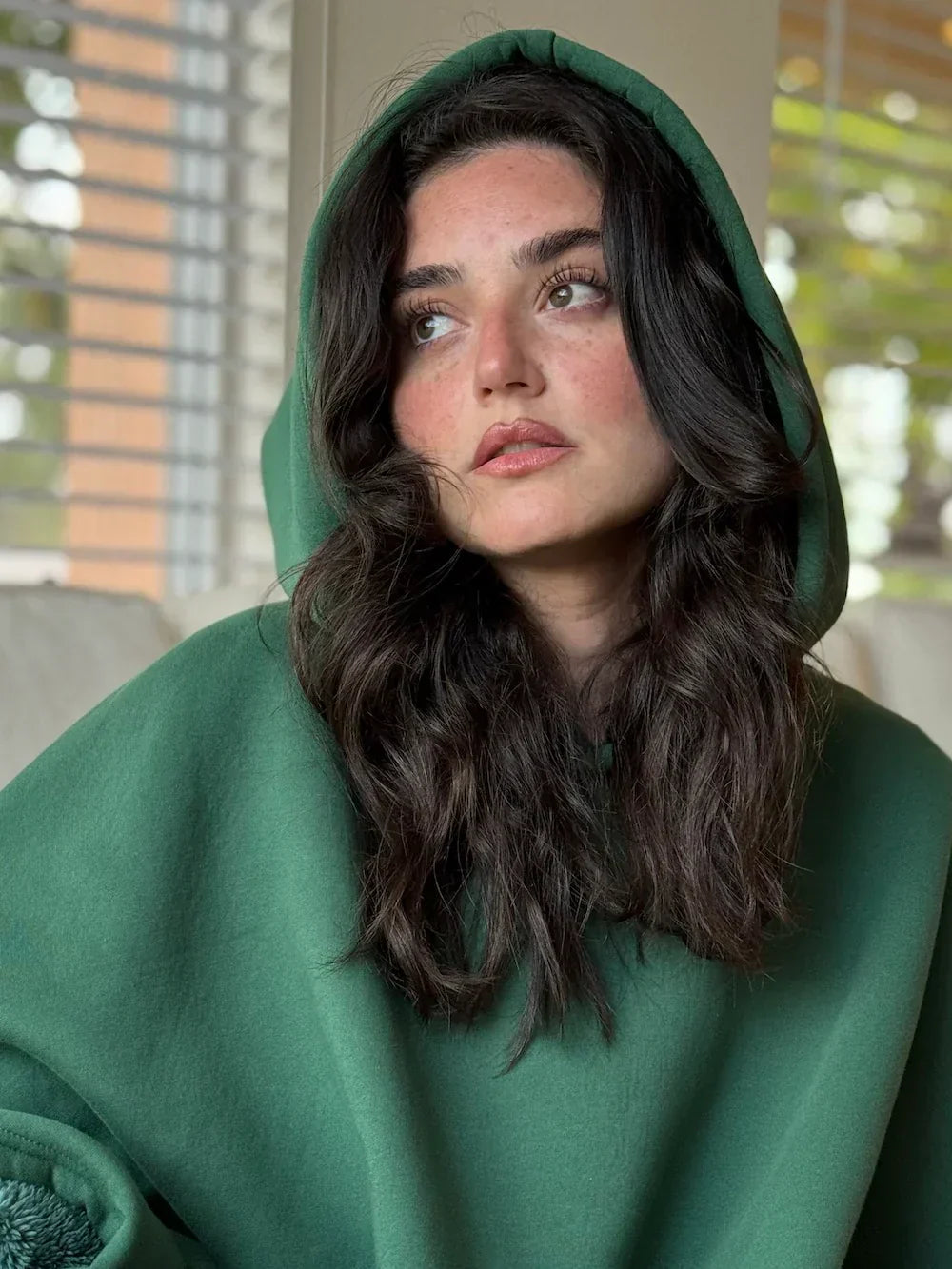 Bluza koc Hugglea w kolorze zielonym z kapturem – kobieta pozuje